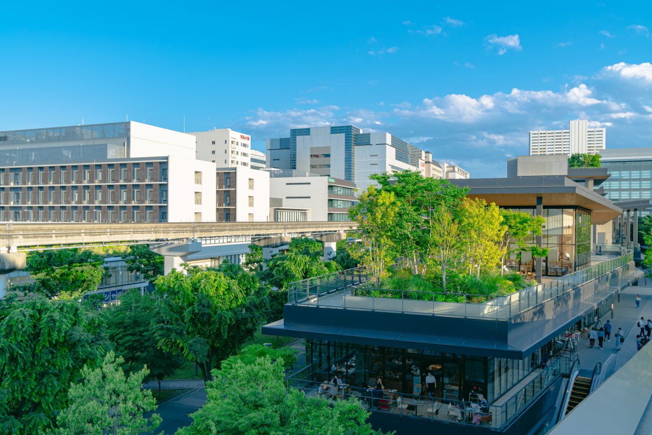 A commercial building with a green-roof terrace planted with trees and shrubs - the kind of sustainable real-estate retrofit EVORA's platform helps measure and manage.