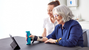 Patient using GripAble device with therapist